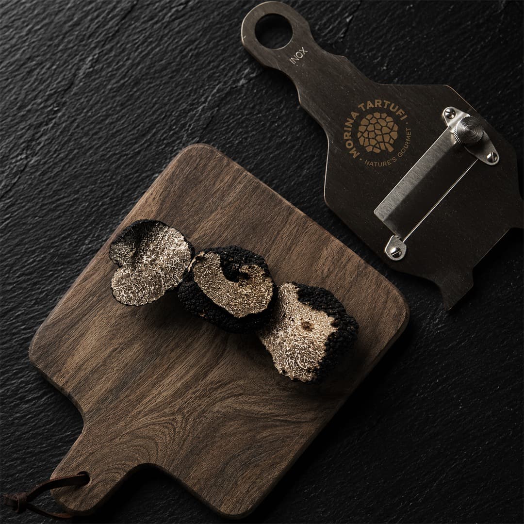 Sliced black truffles on wooden cutting board